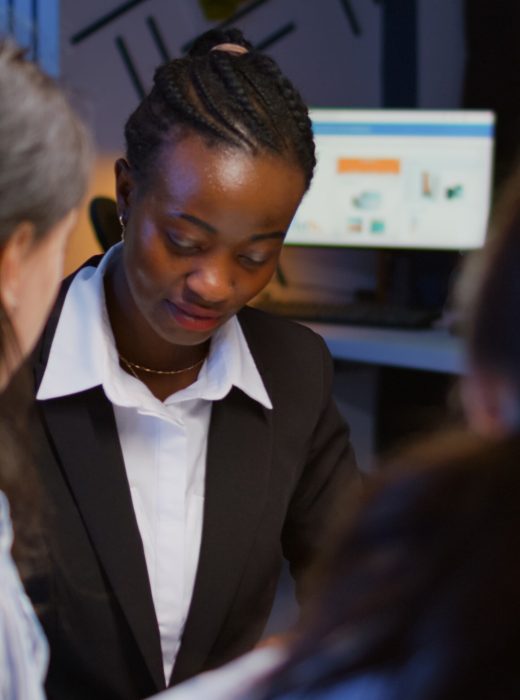 Black african american manager brainstorming company ideas checking management presentation paperwork working overtime in meeting room in evening. Diverse multi ethnic teamwork solving corporate ideas